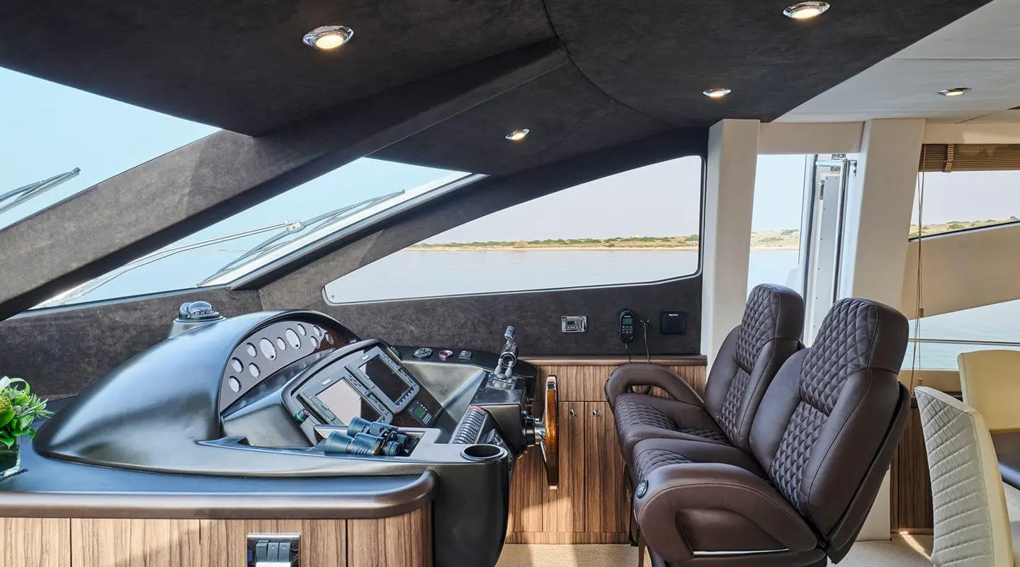 Cockpit with navigation screens and three brown captain chairs in view