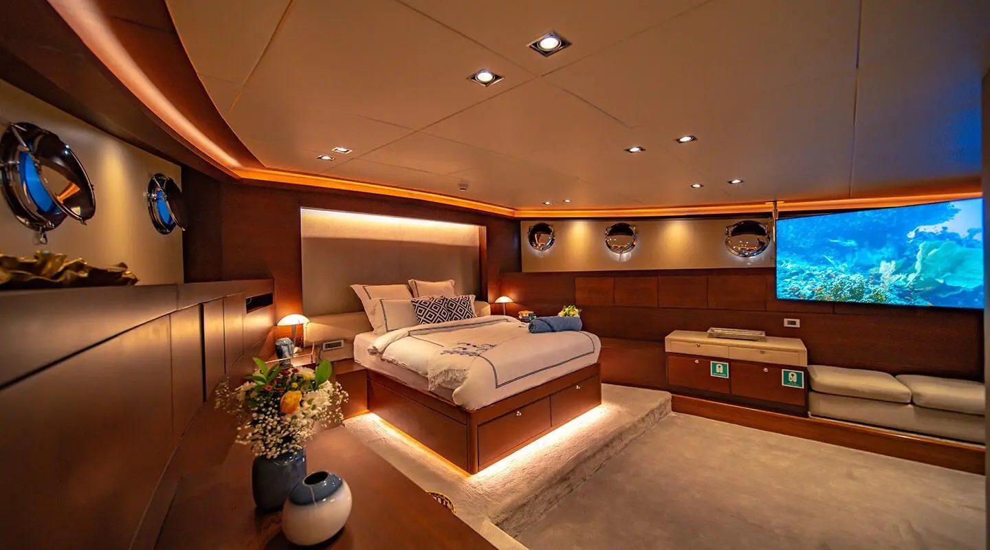Double Eagle yacht interior with a large bed, warm lighting, wood furnishings