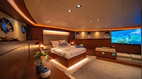 Double Eagle yacht interior with a large bed, warm lighting, wood furnishings