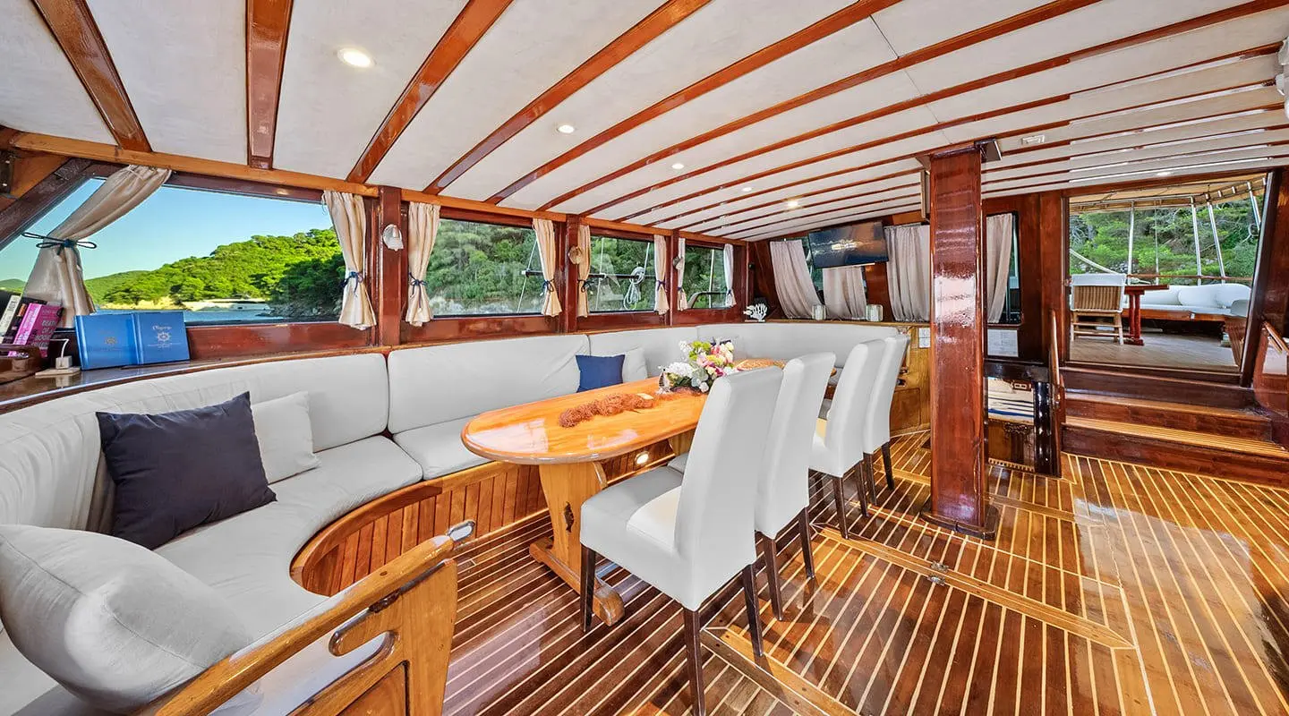 Elegant yacht Eleganza interior with polished wooden deck and seating under a striped covered area