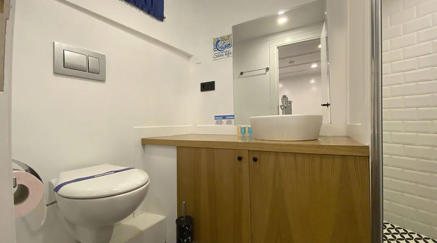 Maske 5 yacht interior bath area with sink, mirror and cabinetry at sunset
