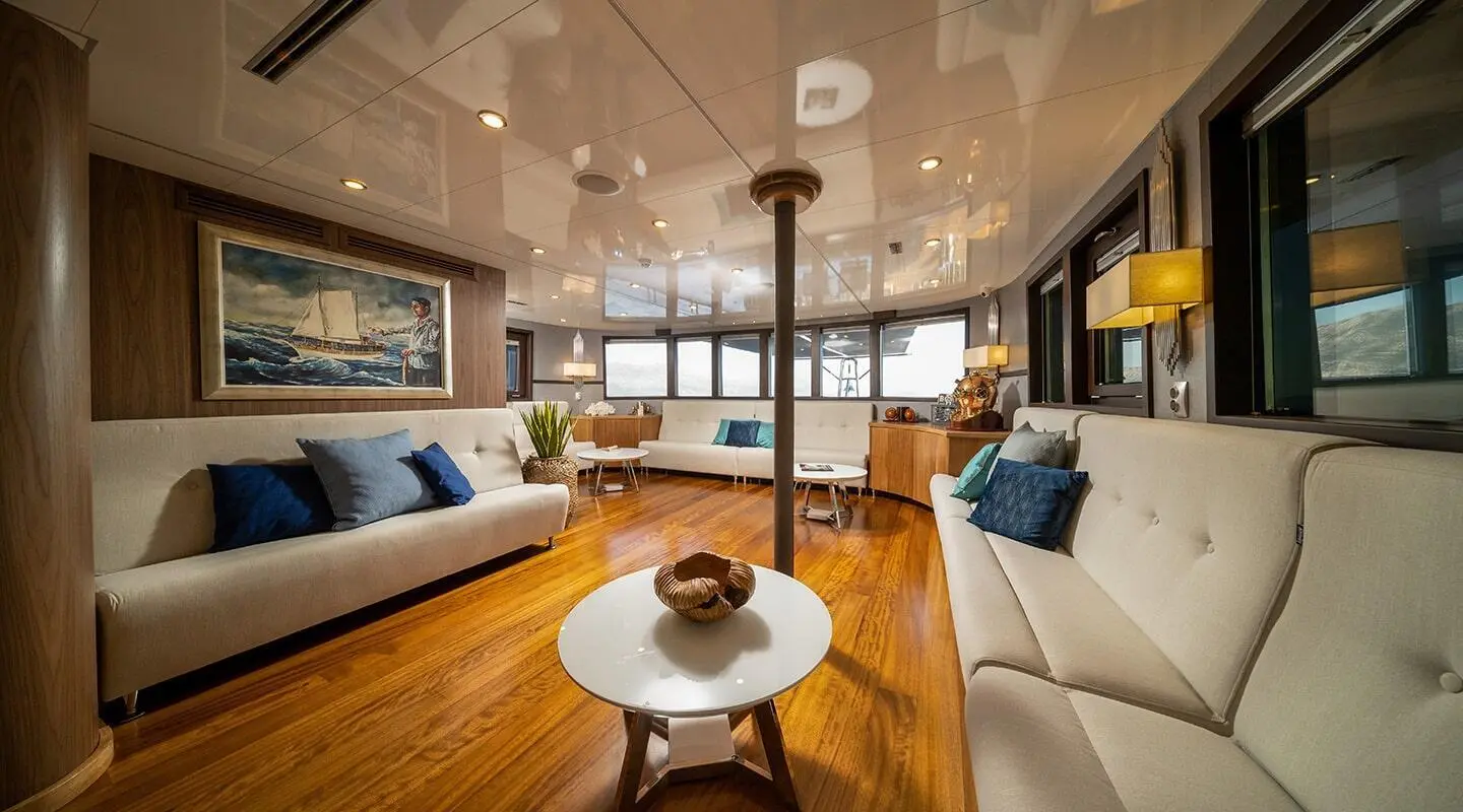 Luxurious yacht Olimp interior lounge with sofas, coffee table, and large windows