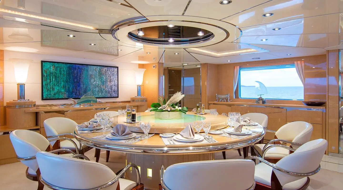 Luxurious yacht interior with round dining table set for guests on O'Natalina