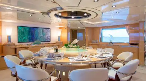 Luxurious yacht interior with round dining table set for guests on O'Natalina
