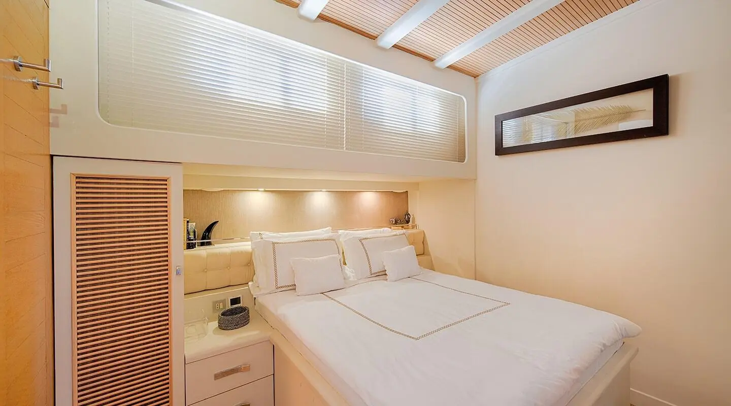 Cobra King yacht interior bedroom with white bedding and wooden accents