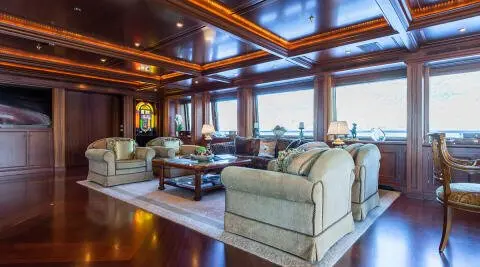 Luxurious yacht Apogee interior with white leather sofas and wooden panels
