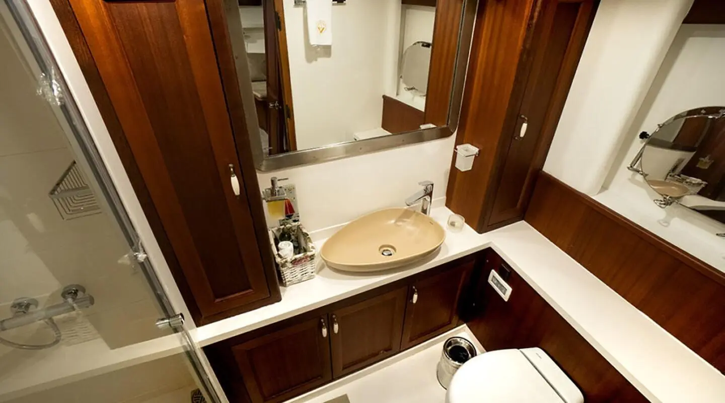 bathroom of the gulet Virtuoso with wood cabinets, shower enclosure and sink