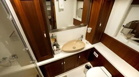 bathroom of the gulet Virtuoso with wood cabinets, shower enclosure and sink
