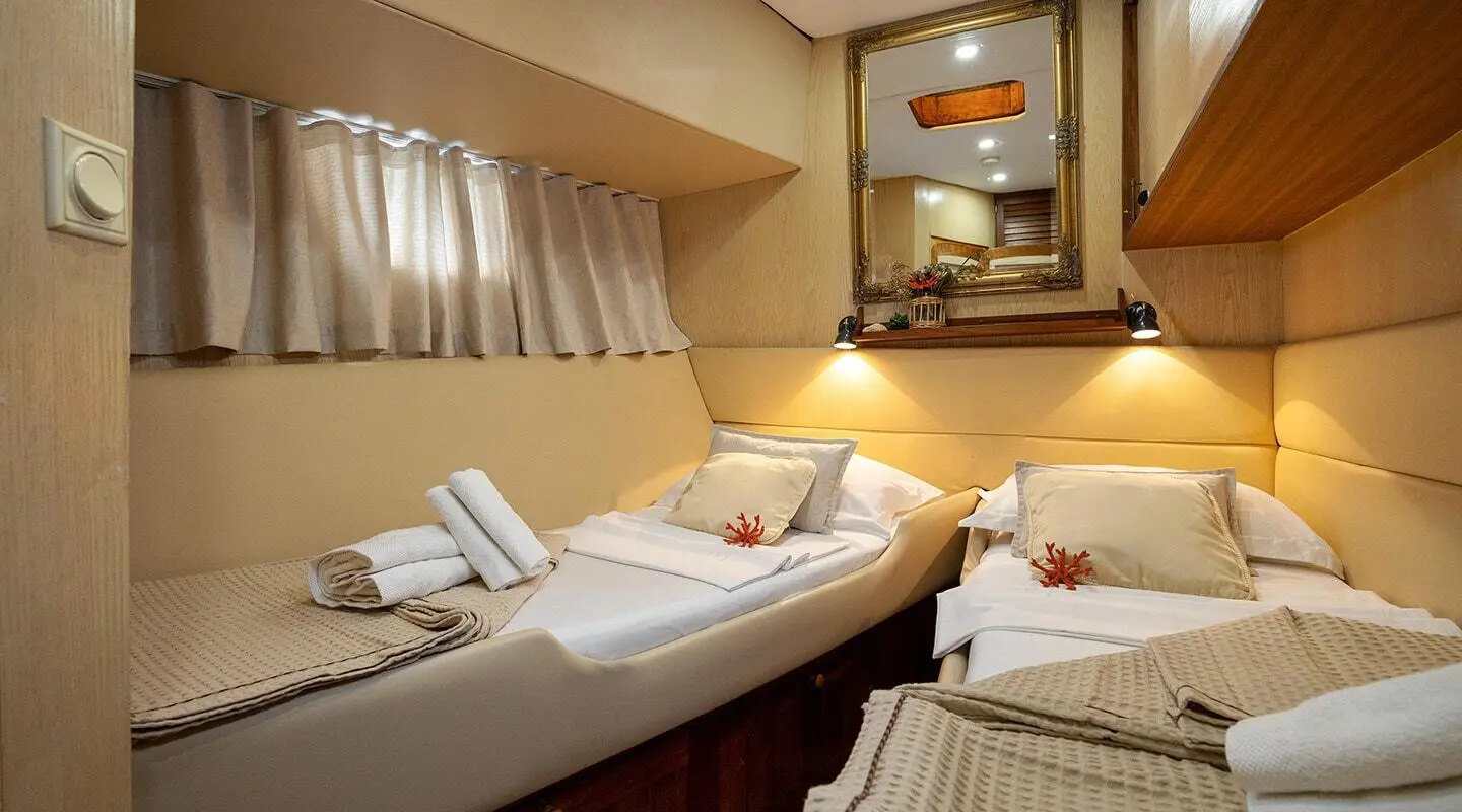 Interior of Aborda gulet with twin cabin, cozy bed and porthole view