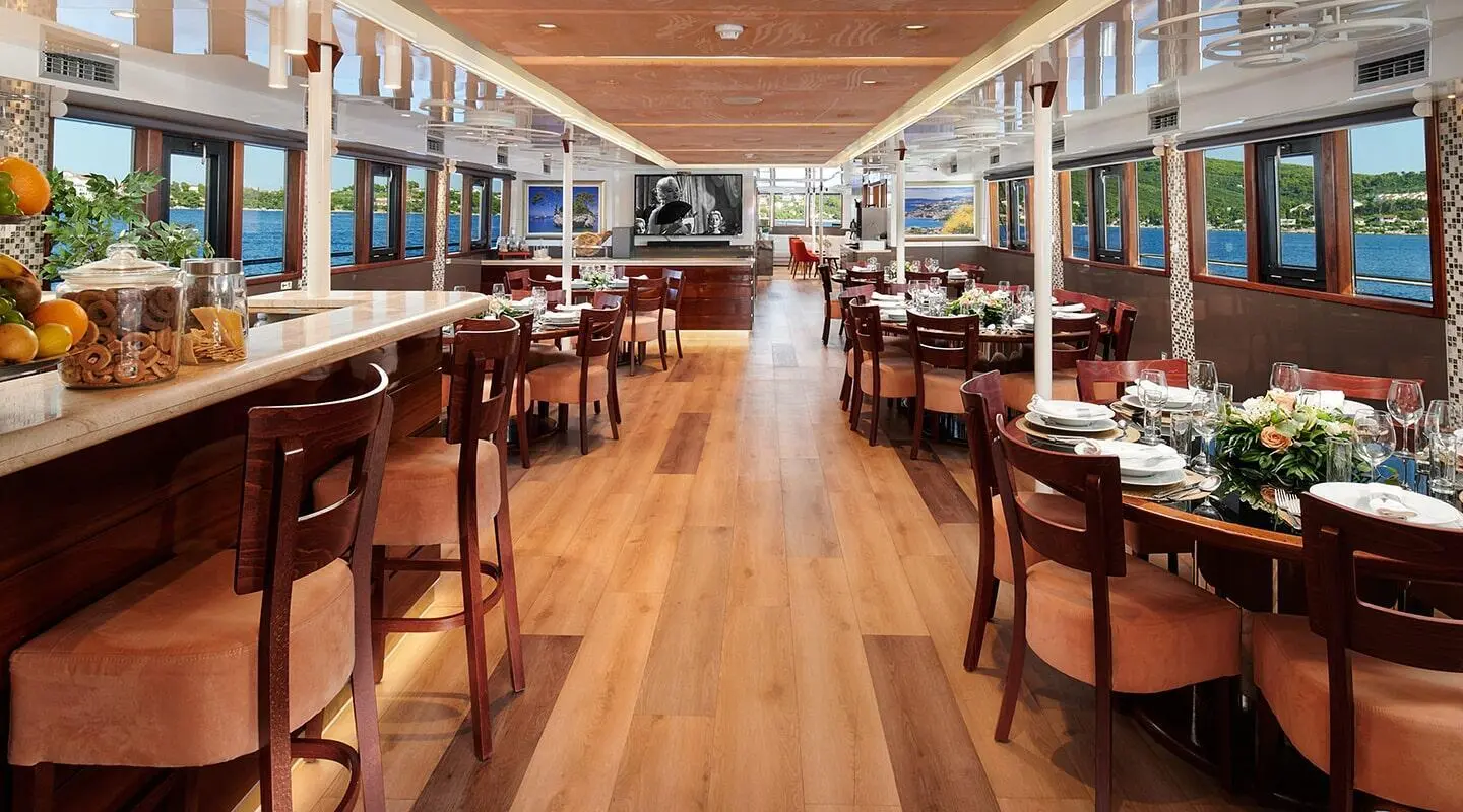 Queen Eleganza yacht dining saloon with wooden floor and dining tables