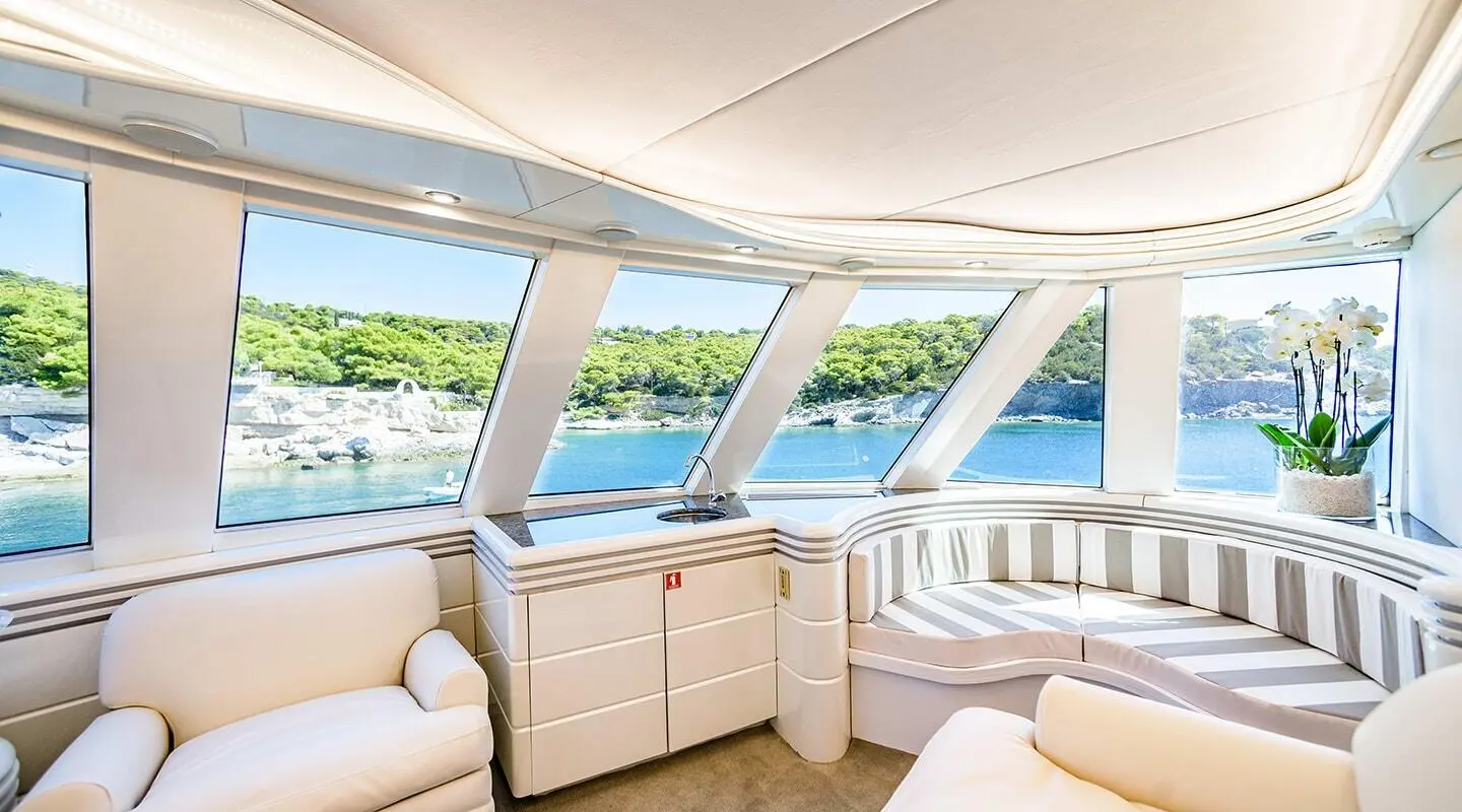 Wind Of Fortune yacht exterior deck with seating and wide windows, calm sea