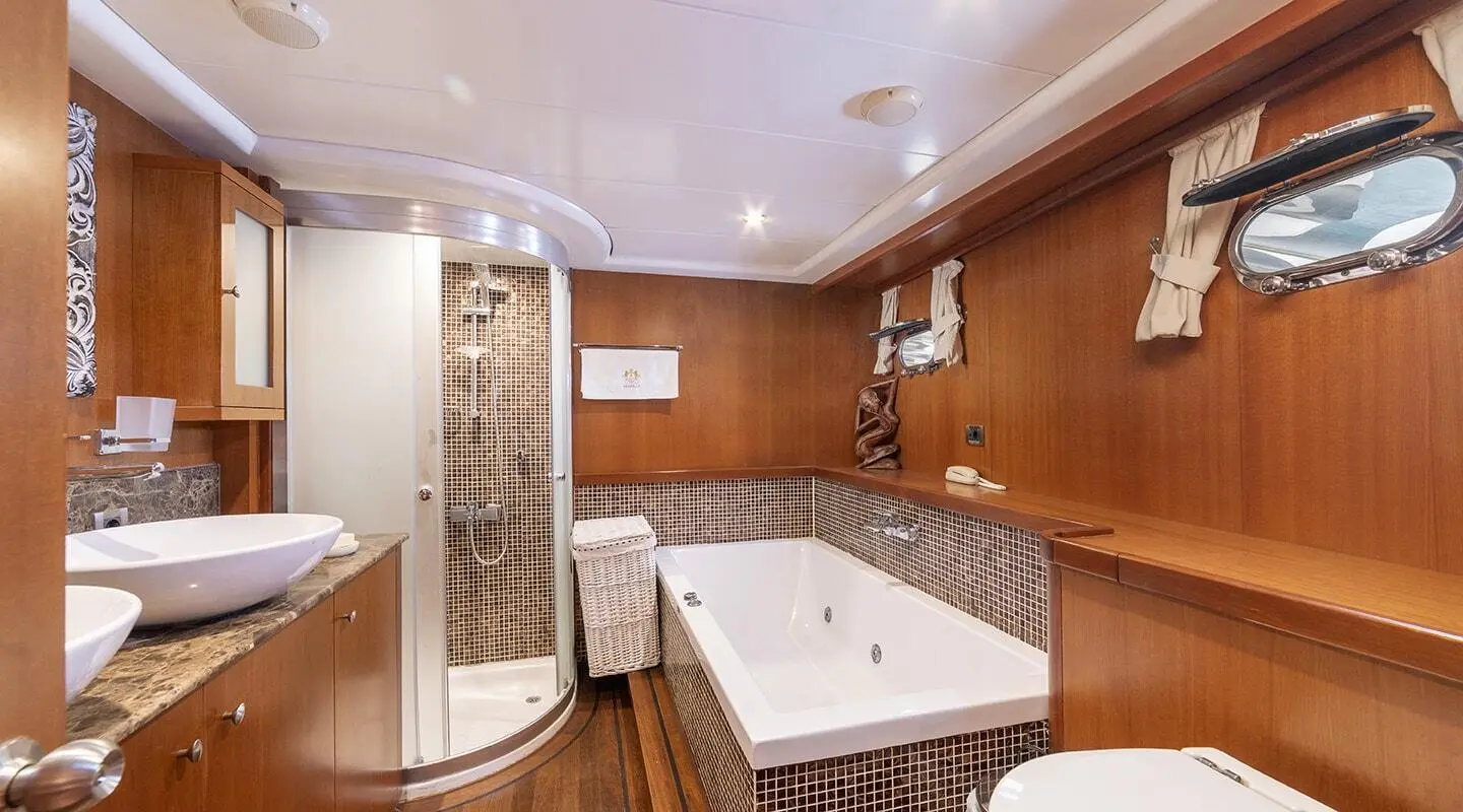Arabella yacht interior with tiled shower, wooden cabinets, and a white tub