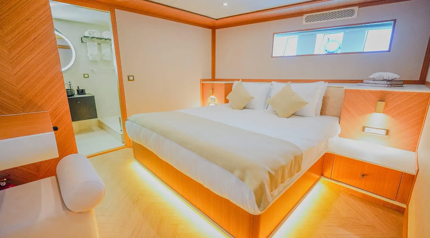 King of the Sea yacht bedroom with warm wood tones, glowing under-bed lighting