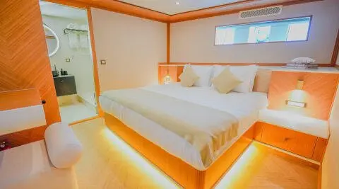 King of the Sea yacht bedroom with warm wood tones, glowing under-bed lighting