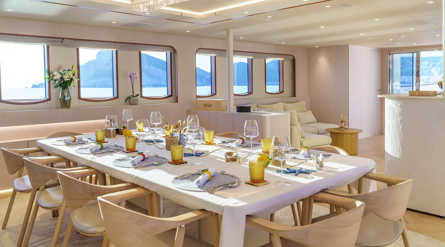 Yacht Maia dining salon with tables set for guests and large windows
