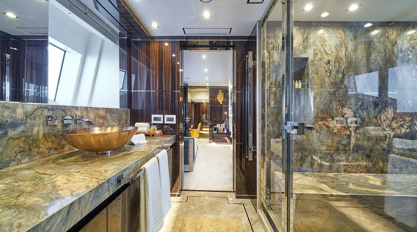 Luxurious yacht bathroom aboard Happy Me with marble countertops and copper basin