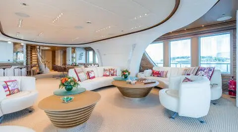 Serenity yacht salon interior at sunset with wicker coffee table and plush seating