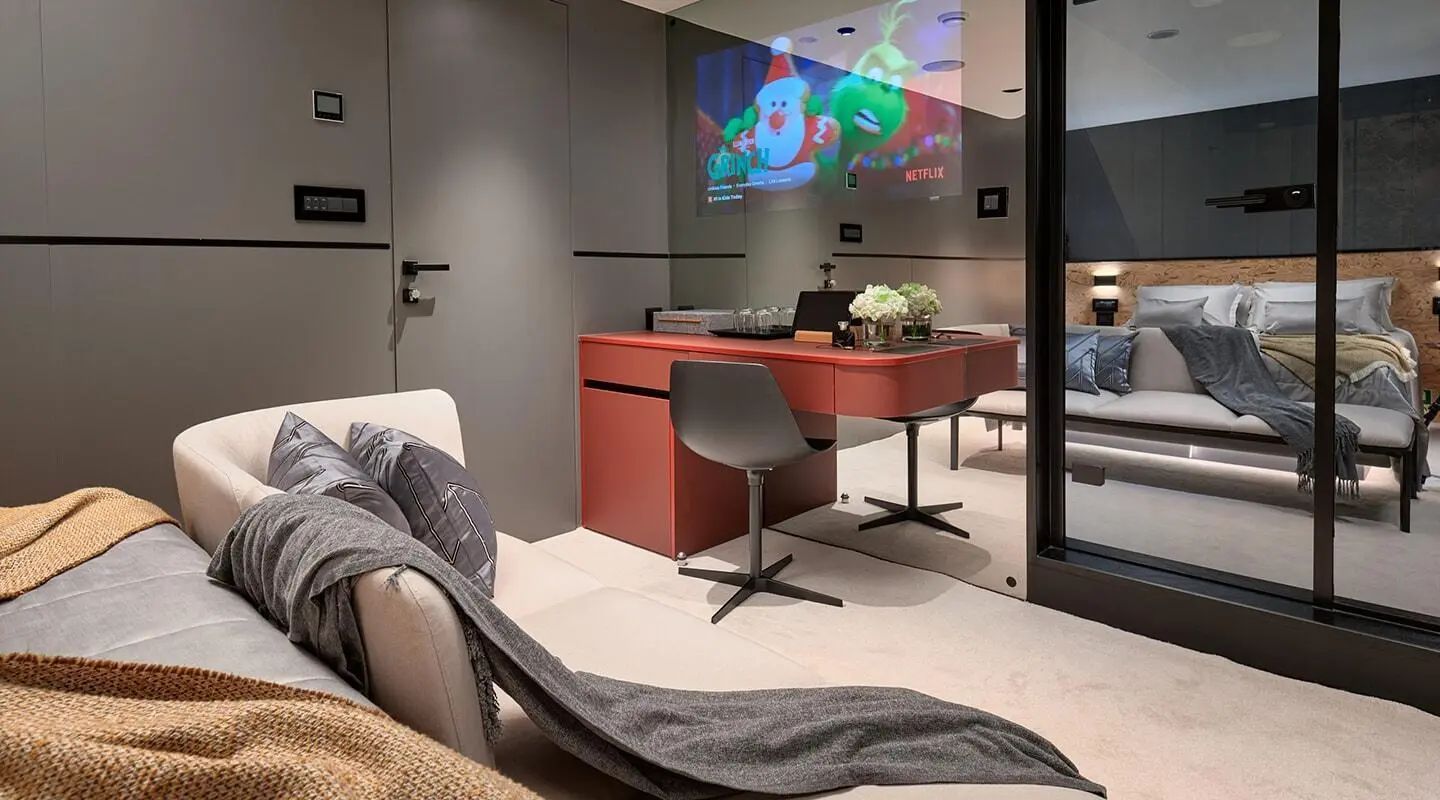 Interior lounge on Anetta yacht with red chairs, curved sofa, and flat-screen TV