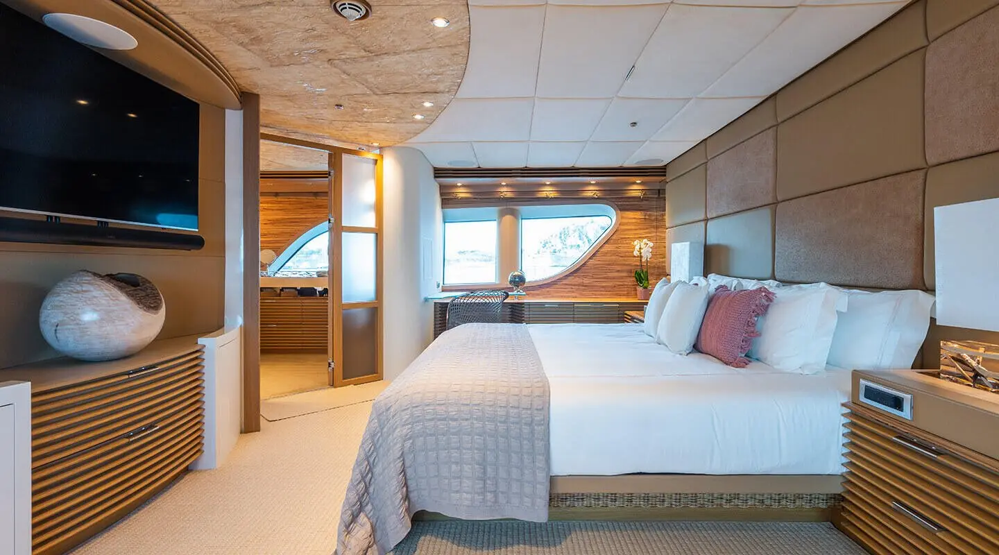 Serenity yacht bedroom with large bed, wooden accents, and soft ambient lighting