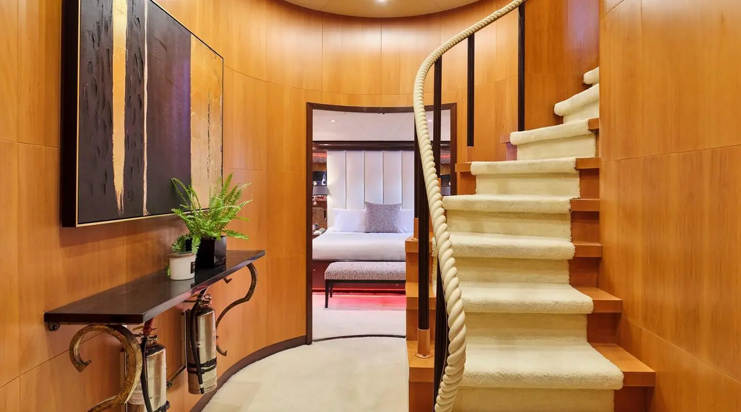 Mobius 38m luxury yacht interior with curved wooden staircase and seating area