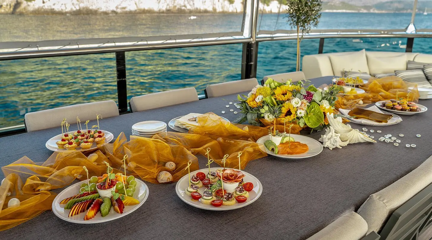 Luxurious yacht Freedom dining scene with plates of food on table and ocean view
