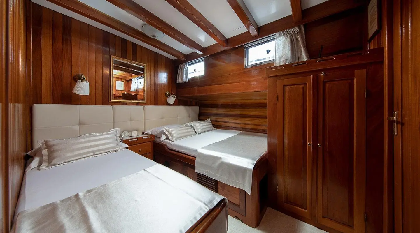 Andi Star yacht interior with wooden paneling and neatly arranged twin beds