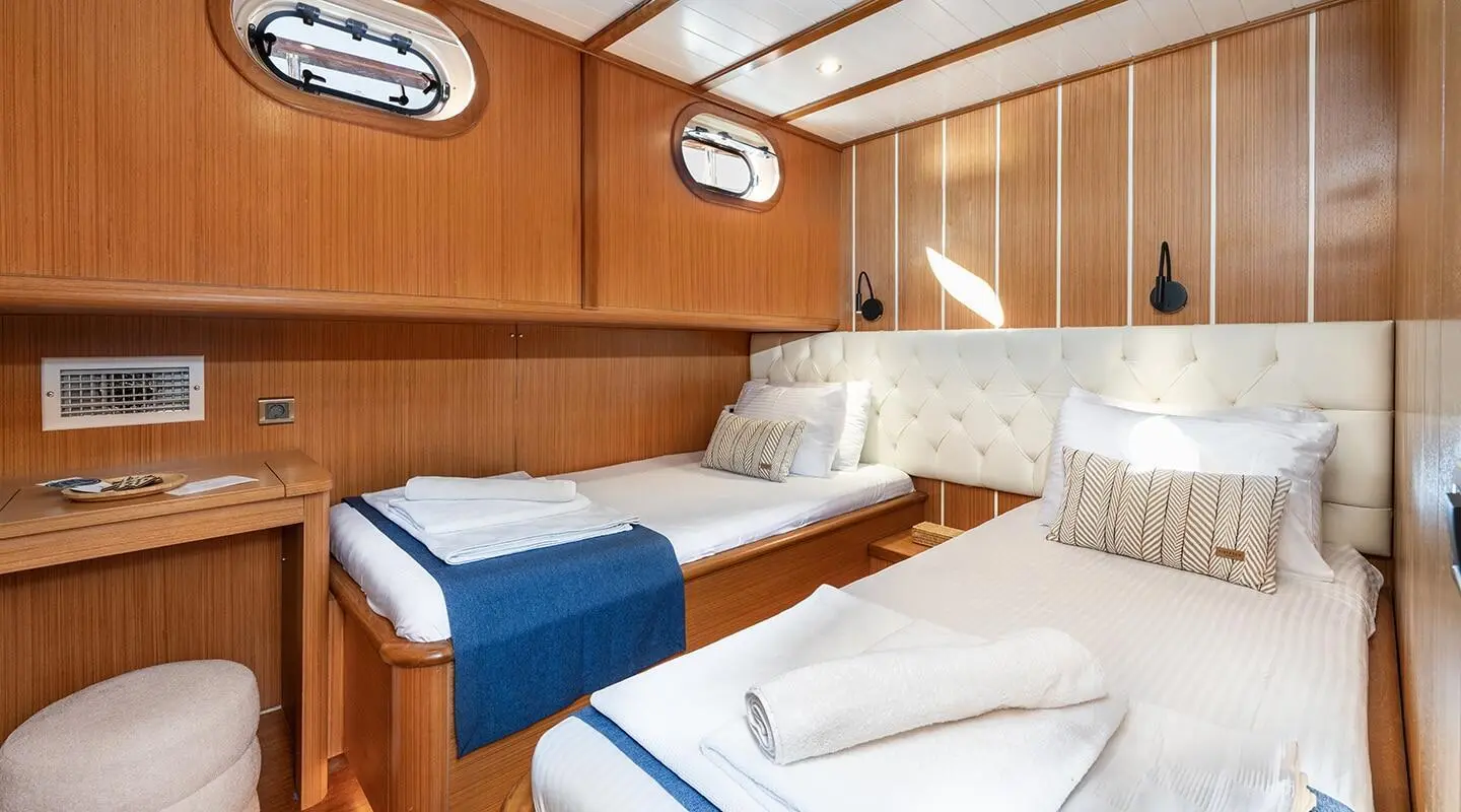 Gozdem The One yacht twin cabin interior with two single beds and wood paneling