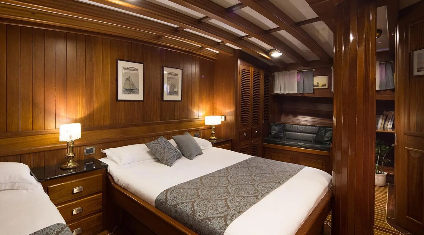 Carpe Diem 7 luxury yacht interior with bed, pillows, wooden panels, warm lighting