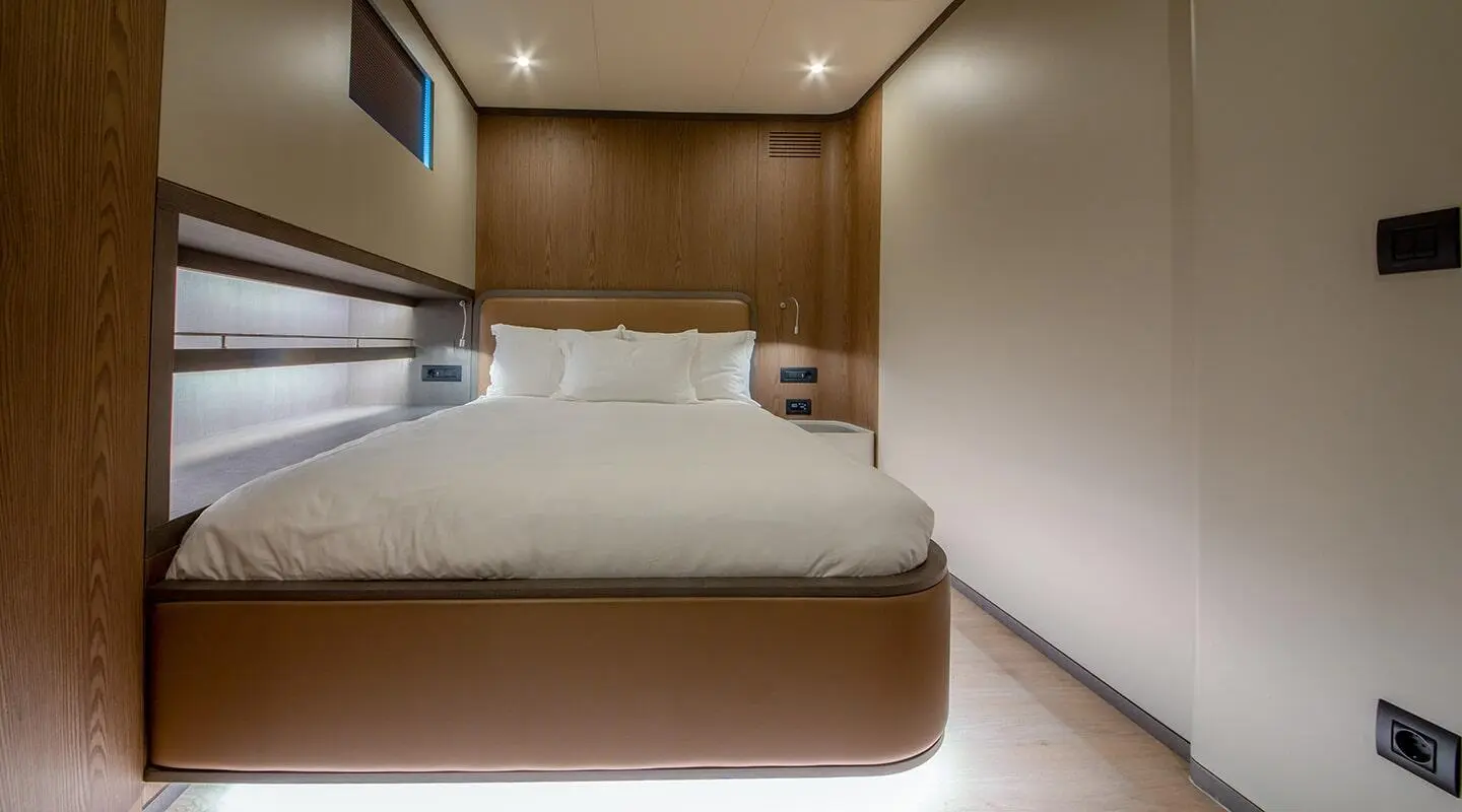 Bedroom with white duvet on a double bed and wooden wall panels inside