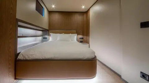 Bedroom with white duvet on a double bed and wooden wall panels inside