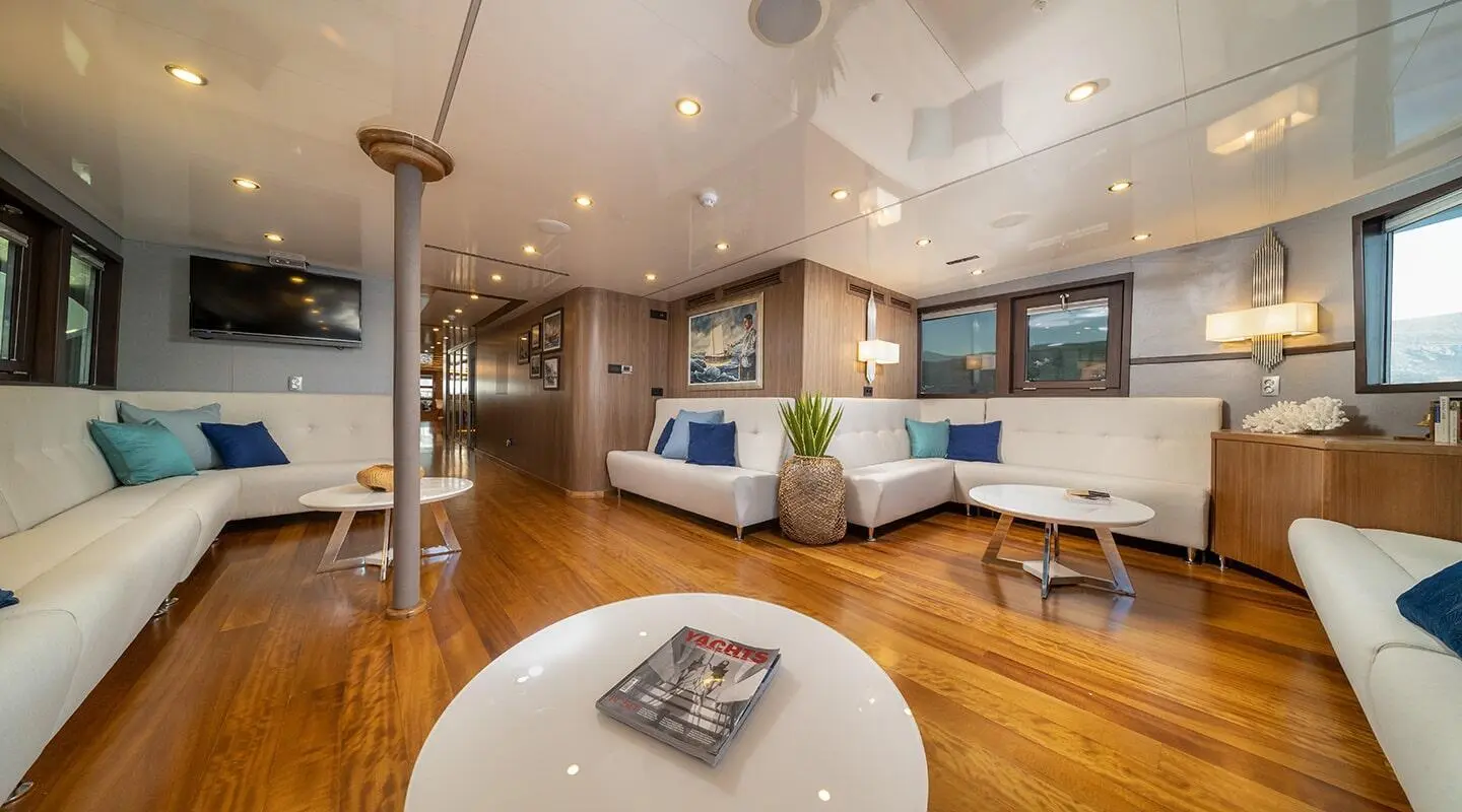 Luxurious yacht Olimp lounge onboard with warm wood floors and white seating