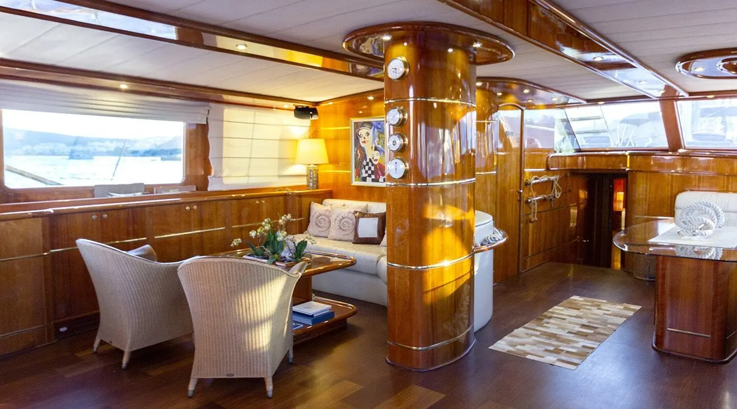 Interior of Silver Moon yacht with polished wood, seating, and helm at sunset