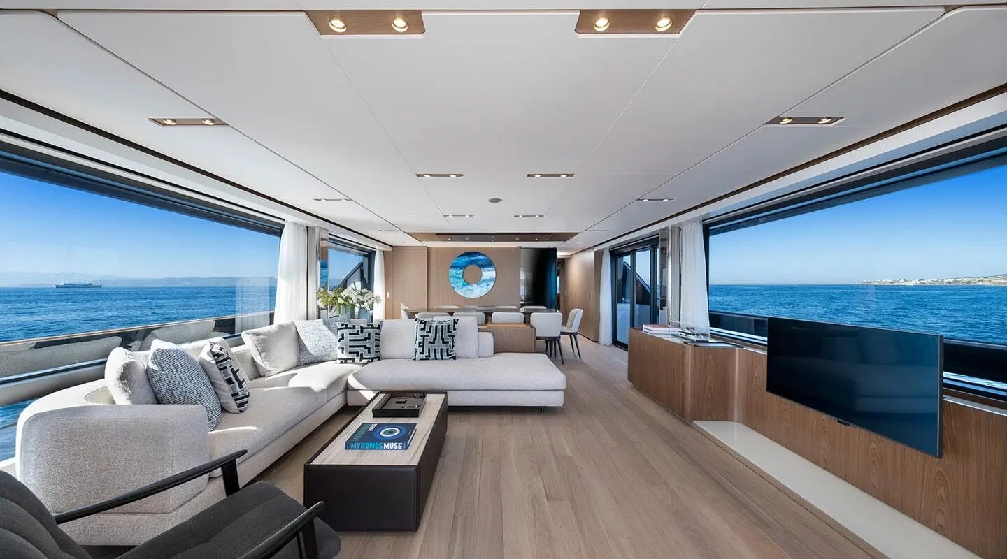 Inside yacht Spica lounge with cream seating, wooden deck, and glass doors