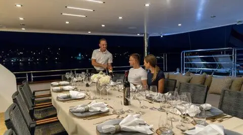 Love Story yacht: elegant dining table aboard sunset-lit luxury gulet at twilight