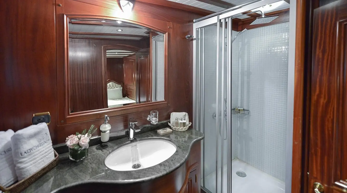 Bathroom on Lady Christa gulet with sink, mirror, and glass shower