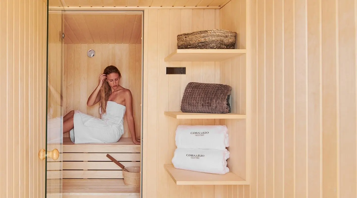 Inside a sauna on Corsario gulet with shelves of towels and a wicker basket