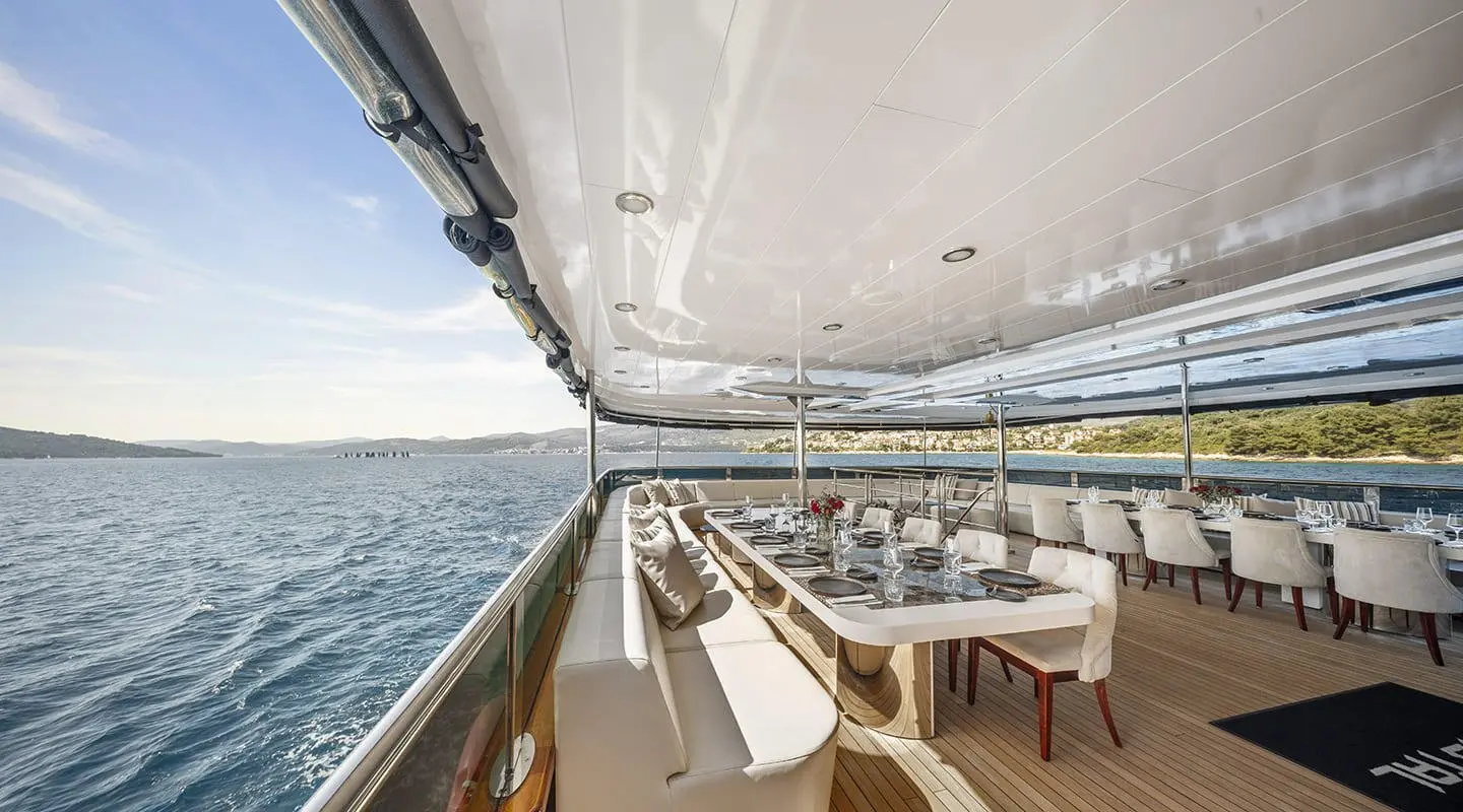 Cristal luxury yacht exterior dining on deck with long table and sea view