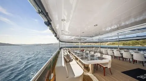 Cristal luxury yacht exterior dining on deck with long table and sea view