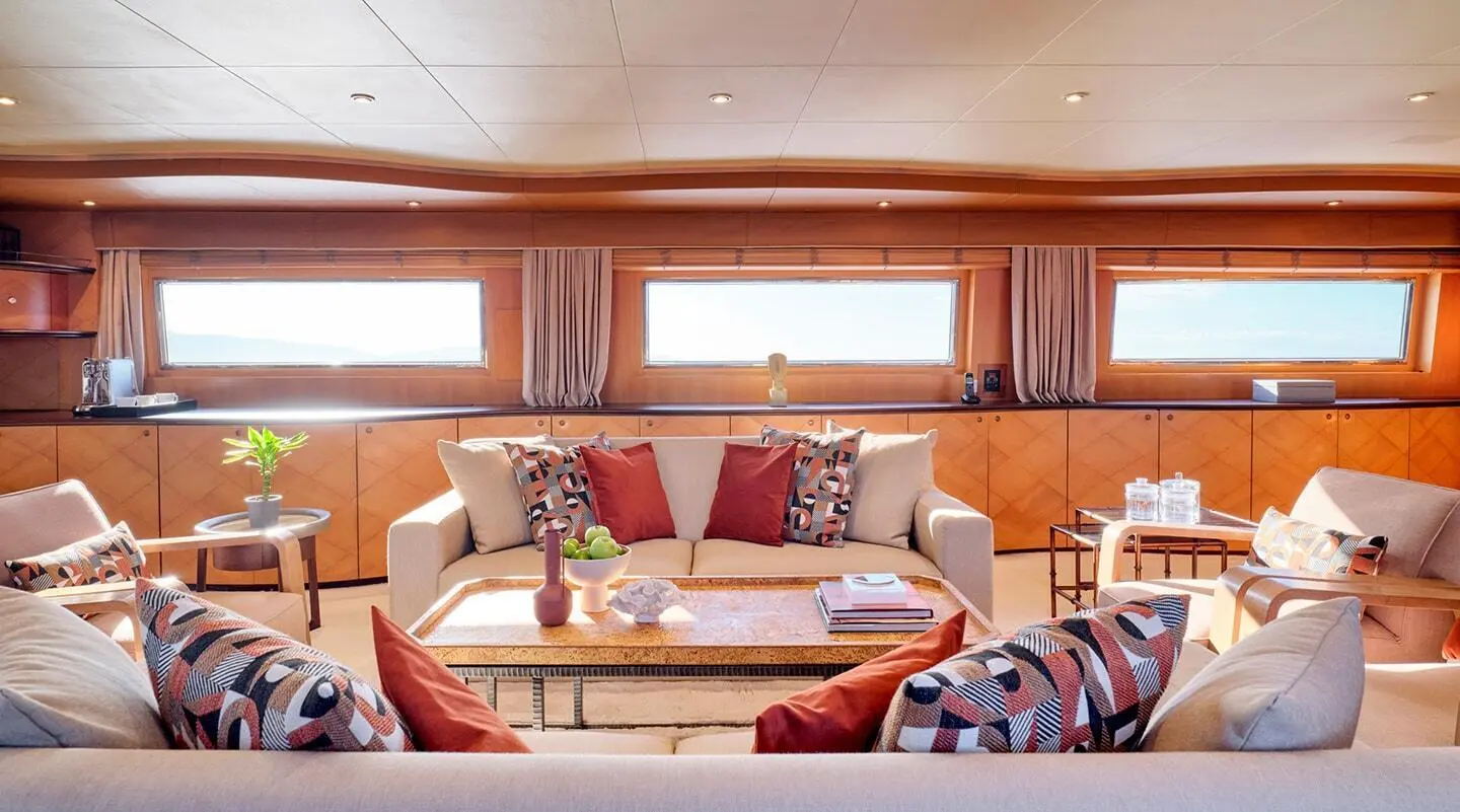 Mobius yacht salon interior with cream sofas, wooden panels, and cushions