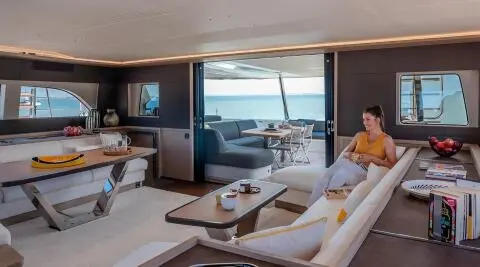 Daiquiri yacht interior lounge at sunset with white sofas and wooden table