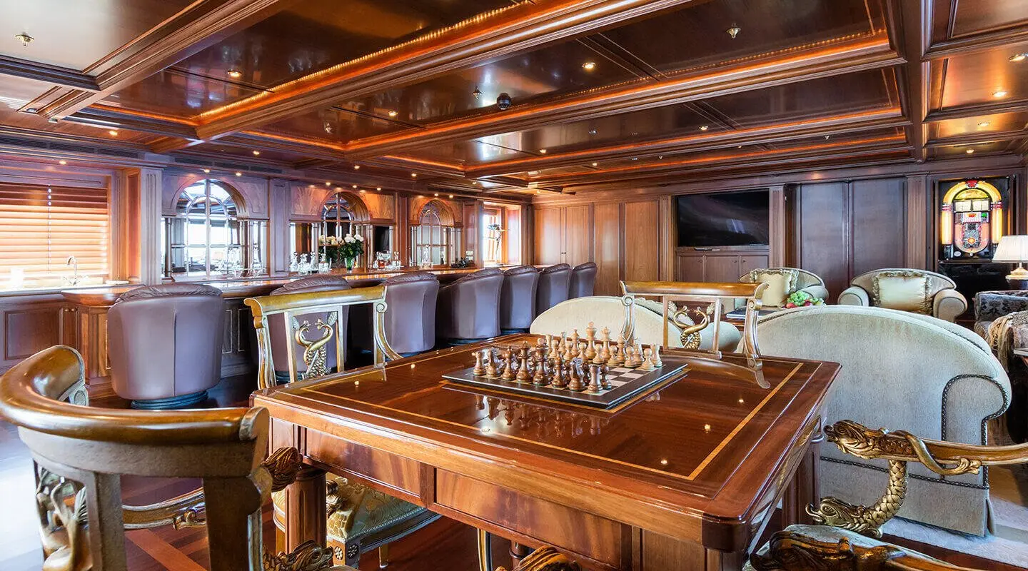 Interior saloon of Apogee yacht with wooden bar and seating area