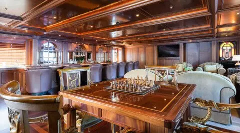 Interior saloon of Apogee yacht with wooden bar and seating area