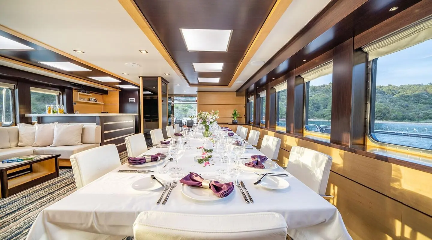 Navilux exterior deck yacht dining area with long table and windows