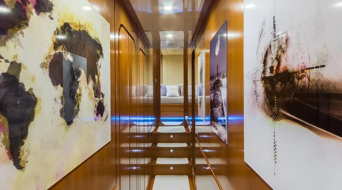 Interior hallway of Amoraki yacht with polished wooden floor and artwork