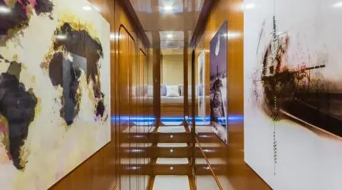 Interior hallway of Amoraki yacht with polished wooden floor and artwork