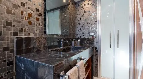 Interior bathroom on gulet Long Island yacht, stone tiles and mirror cabinet