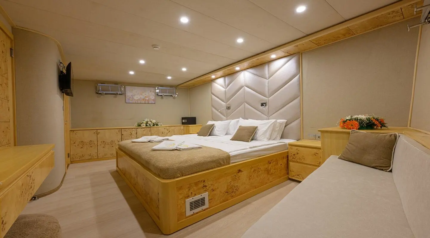 Luxurious yacht interior with large bed, wood accents, and ambient lighting