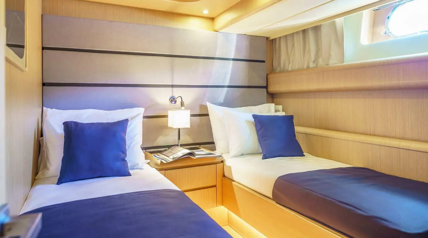 Interior of Phantom yacht cabin with two blue pillows and warm lighting