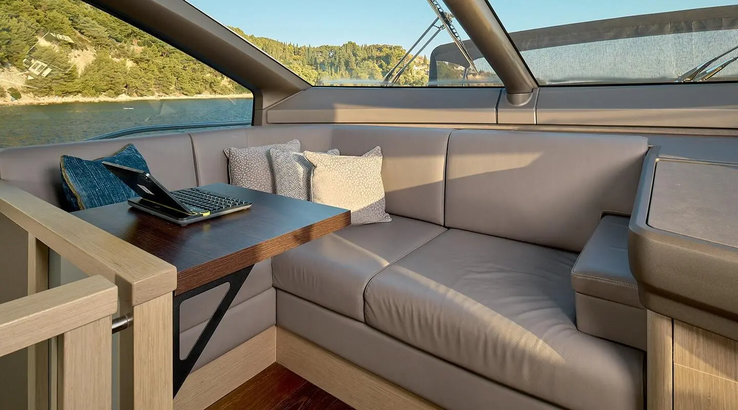 Yacht Hideaway salon seating with light cushions and glass door view
