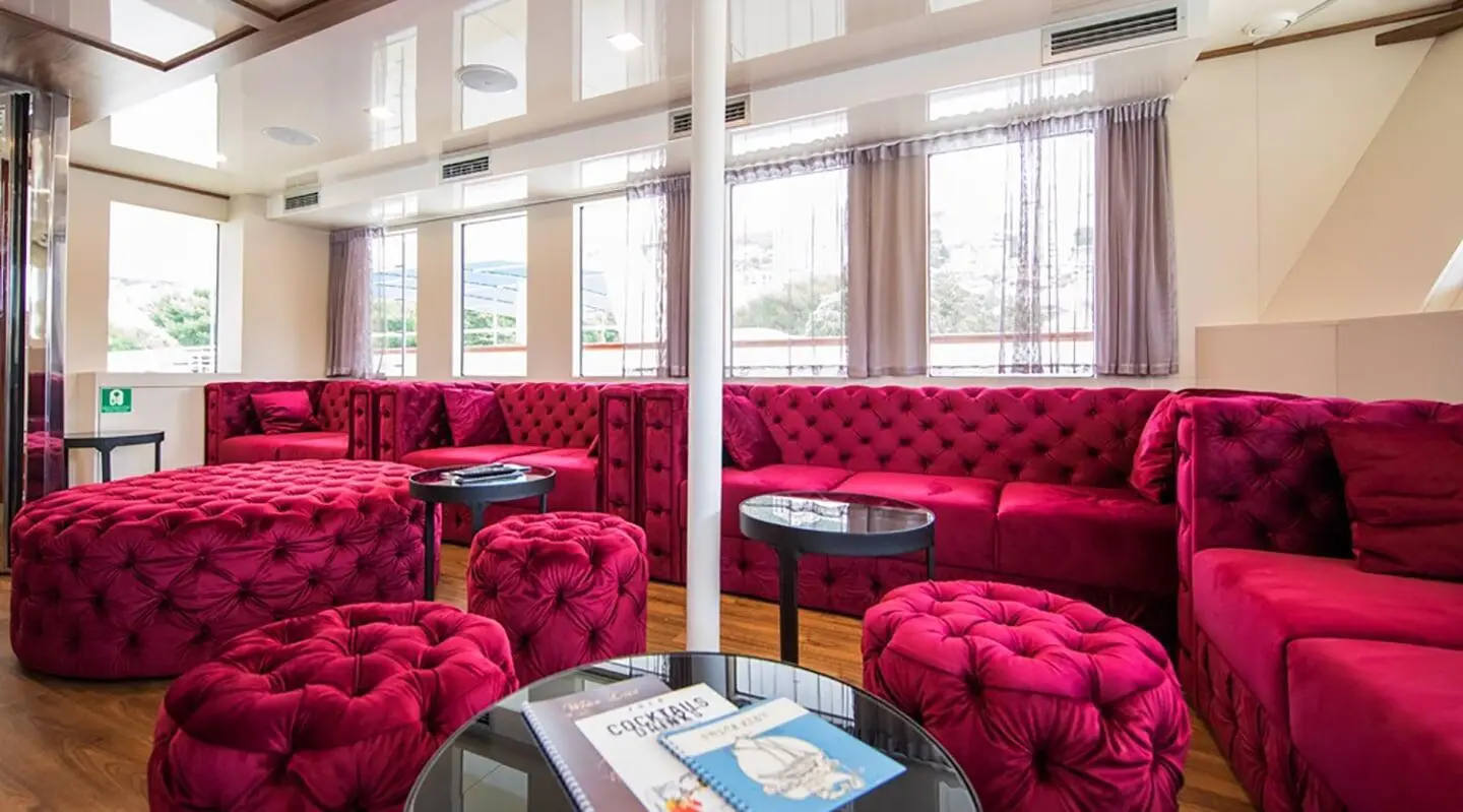 Yolo luxury yacht lounge with red velvet seating and large windows